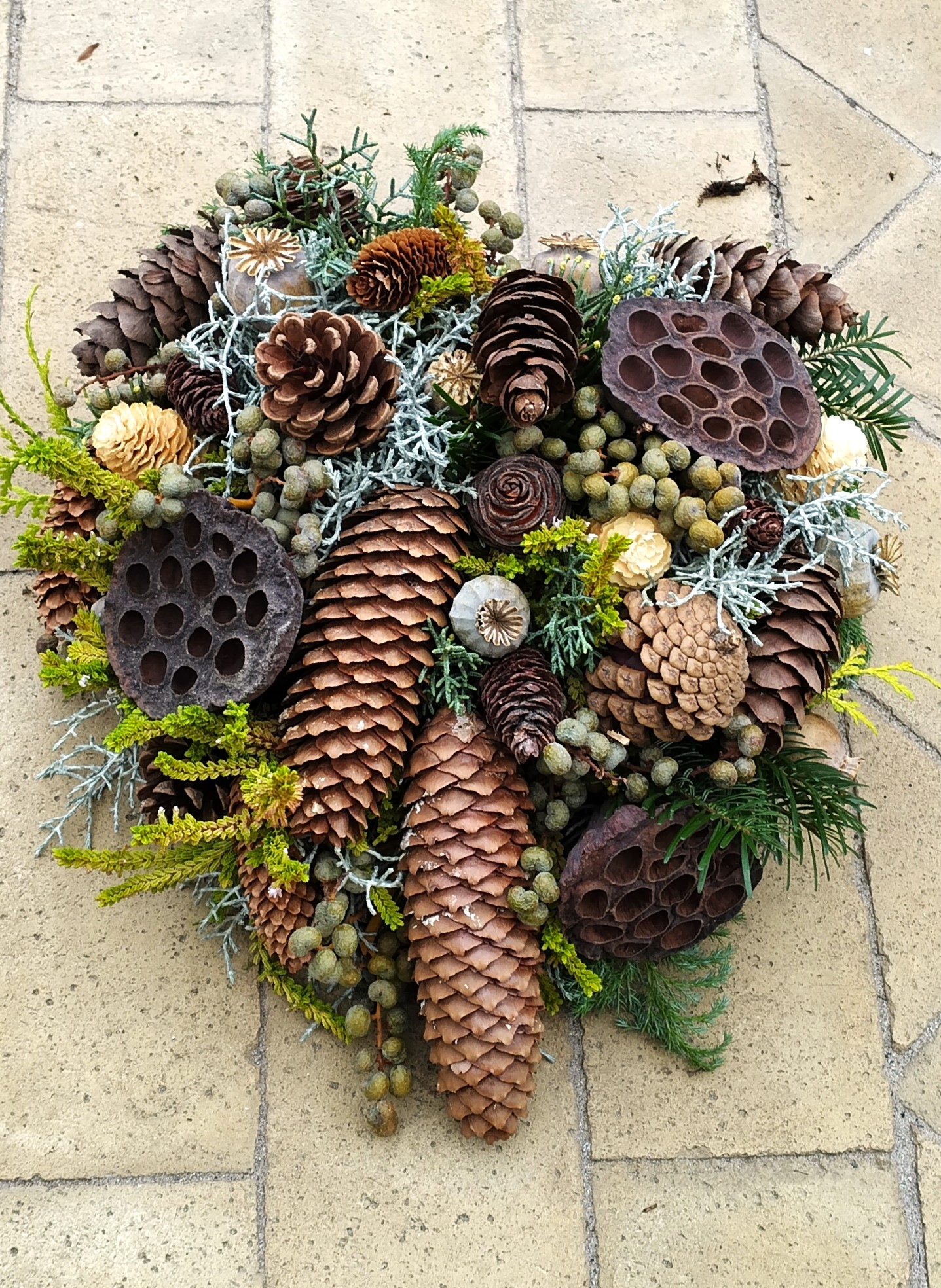 Bæredygtigt gravhjerte med kogler, grønt og forskellige materialer. 