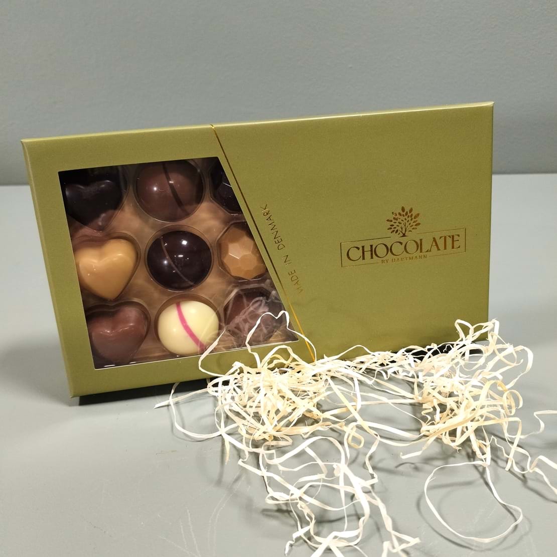 Guldfarvet chokoladeæske fra Hartmann, med forskellige fyldte chokolader.