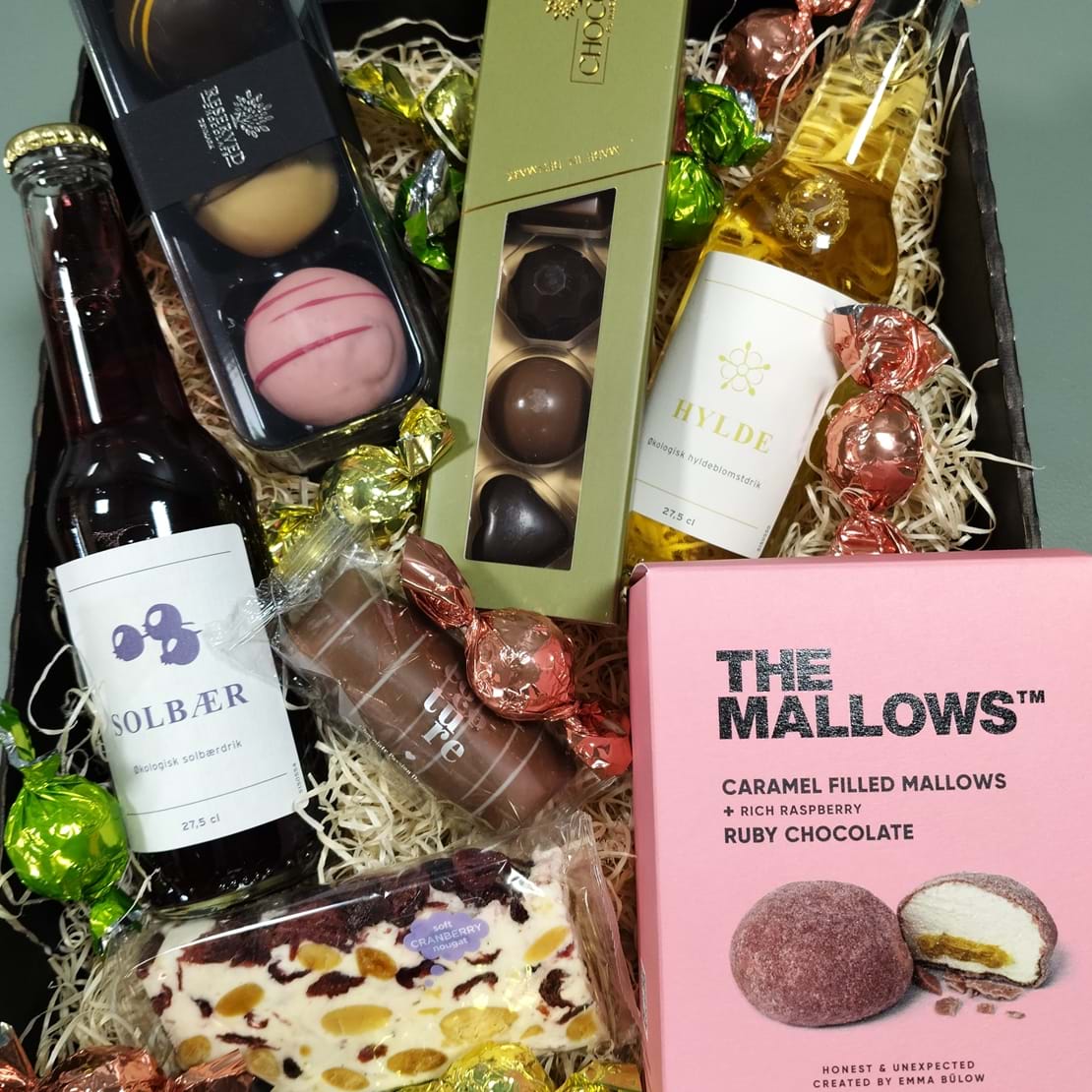 Gavekurv med slik, konfekt, solbær og hyldeblomstdrik, skumfiduser, romkugler og fyldte chokolader.