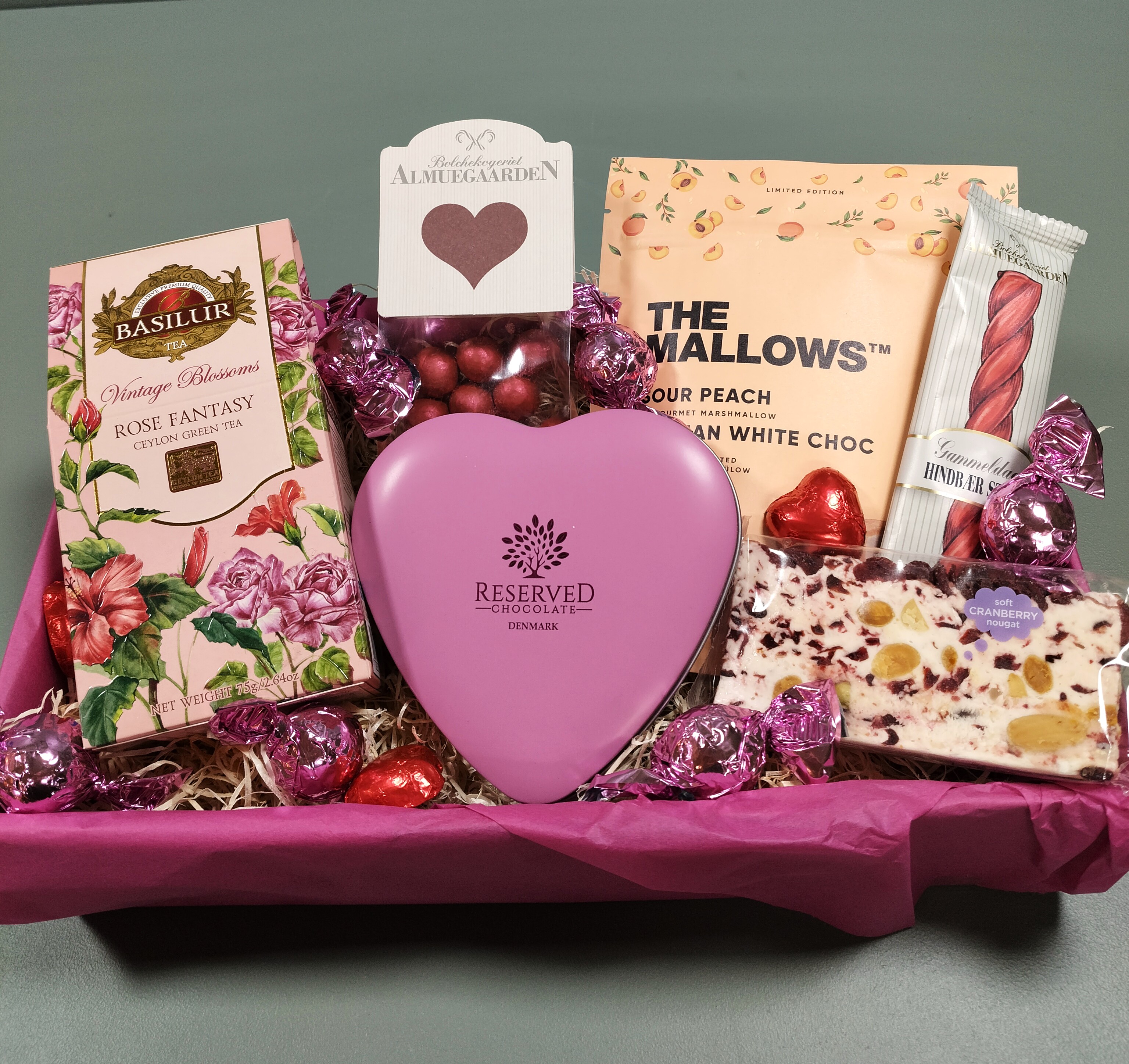 Romantisk gavekurv med chokolade, te, marshmallows og hjerteæske i pink farver