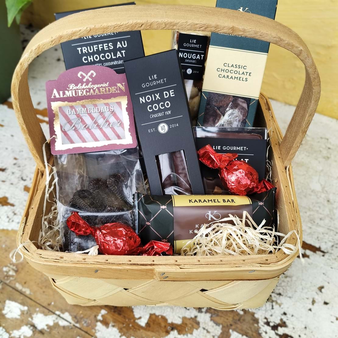 Gavekurv fyldt med bolcher, karamelbar, noix de coco, chokoladekarameller og trøffelchokolader.