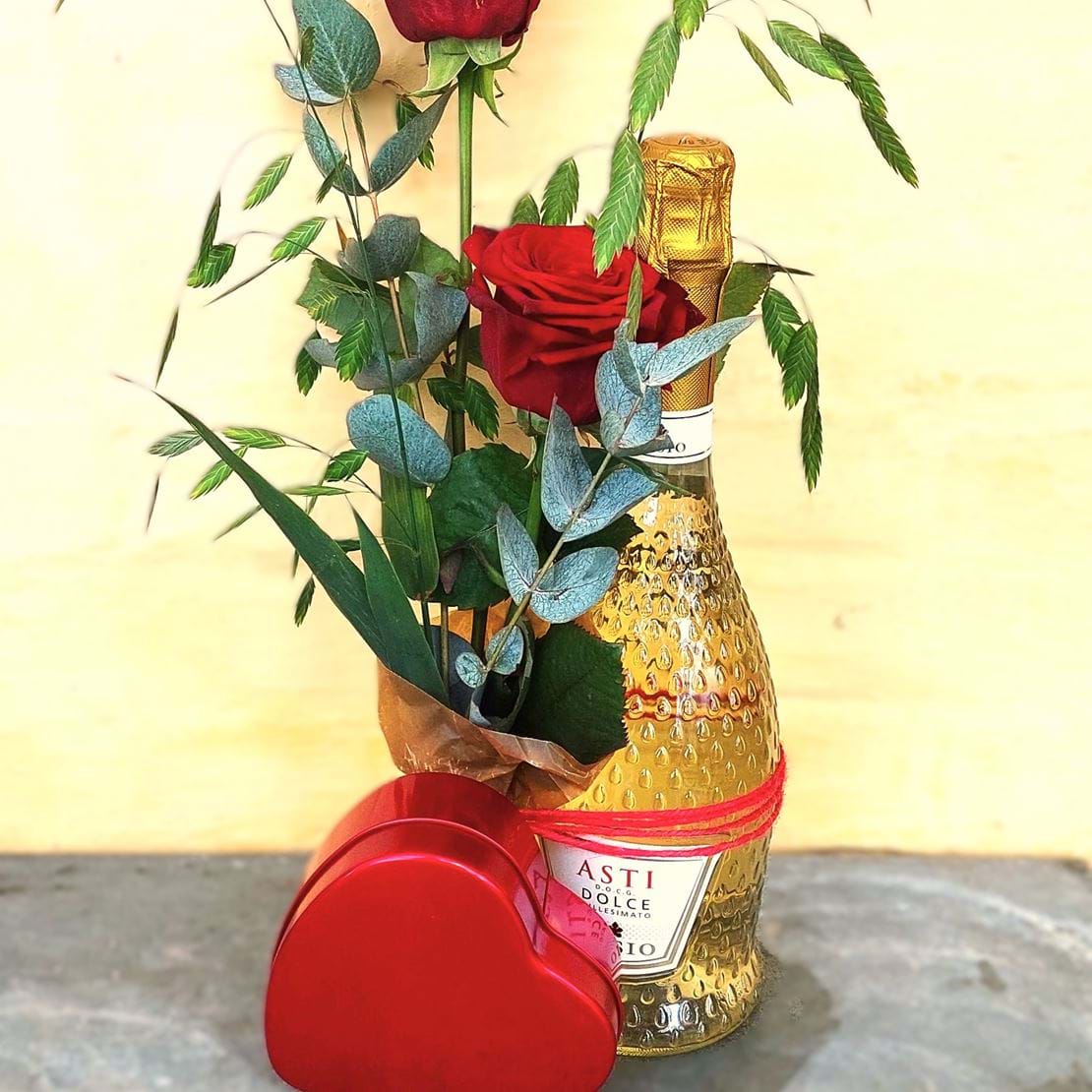 Mors dags gave med en flaske Asti, et rødt chokolade hjerte og røde roser. 